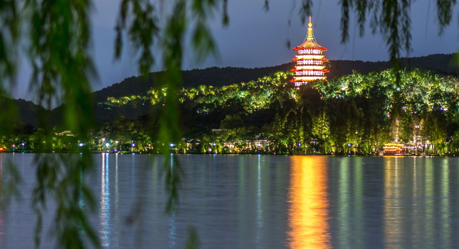 Pagoda de Leifeng iluminada poco después de la caída del sol, proyectando su reflejo dorado sobre el Lago del Oeste de Hangzhou