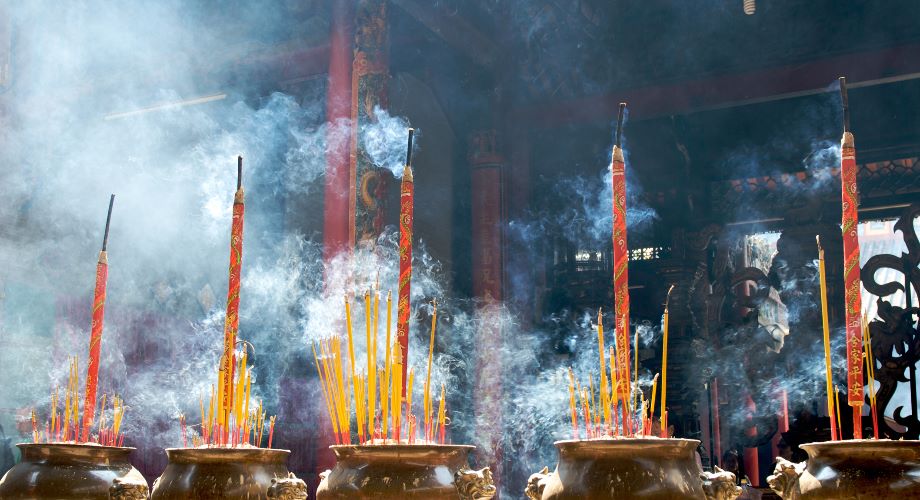 Wierookstokjes vullen het donkere interieur van de Chua Ba Thien Hau-tempel in Ho Chi Minh stad met rook