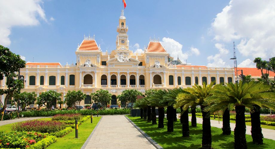 Het stadhuis van Ho Chi Minh stad in Franse koloniale stijl te midden van goed onderhouden tuinen 