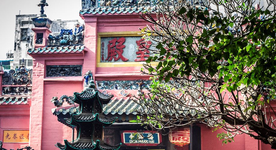 De roze muren en fijn afgewerkte zwarte daken van de Jade Emperor Pagoda in Ho Chi Minh stad