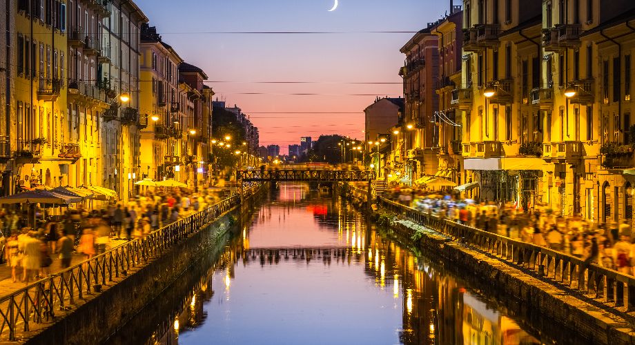 People walking on either side of Milan’s Naviglio Grande in the evening