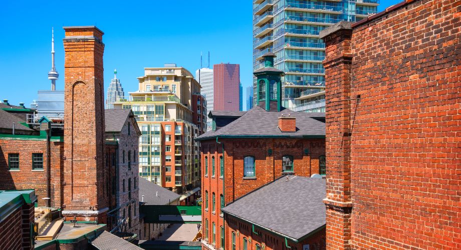 Old buildings with skyscraper in the background of Toronto’s Distillery District
