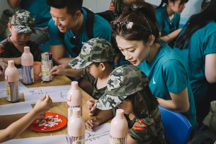 A group of volunteers are assisting for the child drawing
