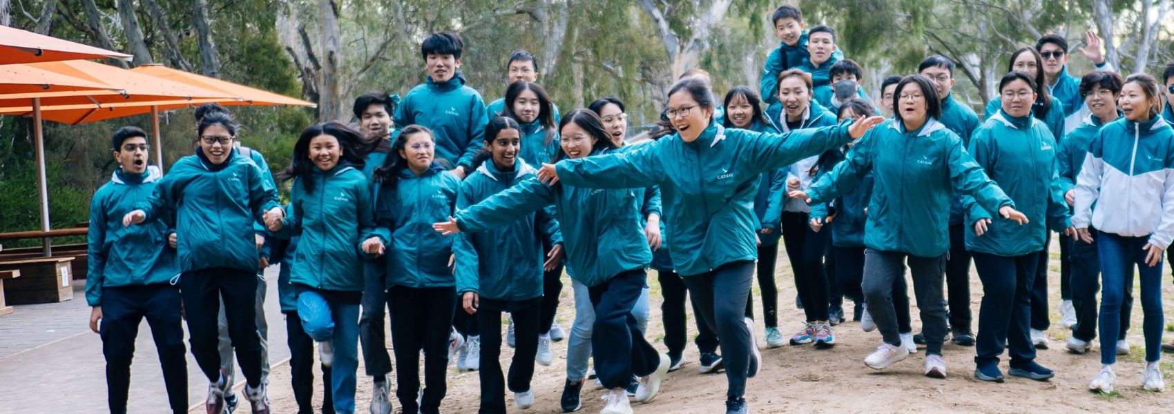 Group of "I can fly programme" student jumping in front of the plane 