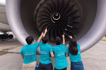 A group of people standing in a line with their hands up