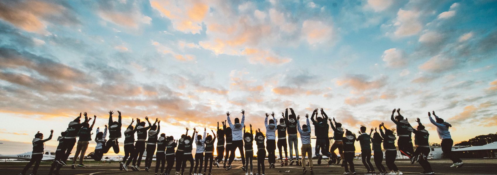 A group of people standing in a line with their hands up