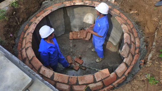Công nhân chế tạo bếp tiết kiệm củi cho một hộ gia đình. 