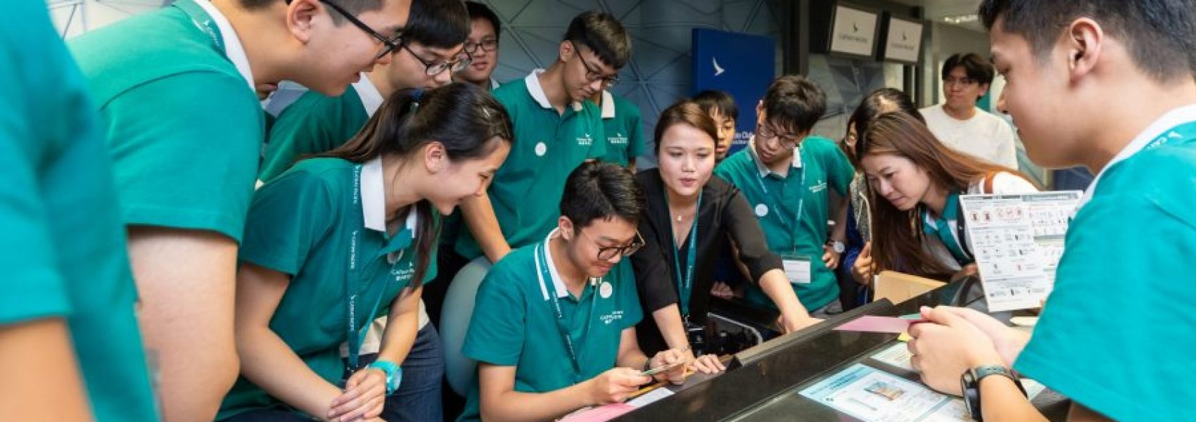 A group of students from the "I Can Fly" program stood around the registration counter, listening to the instructor's explanation.