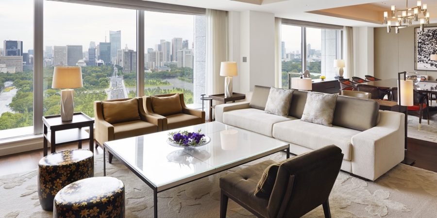 A bright living room with large windows showcasing a stunning view of the city skyline.