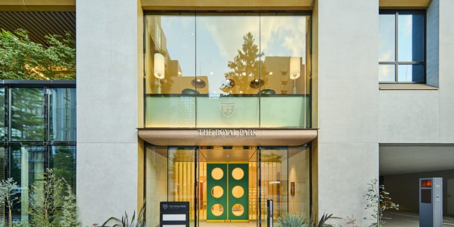 A contemporary structure with a vibrant green door and expansive glass windows, highlighting its modern architecture.