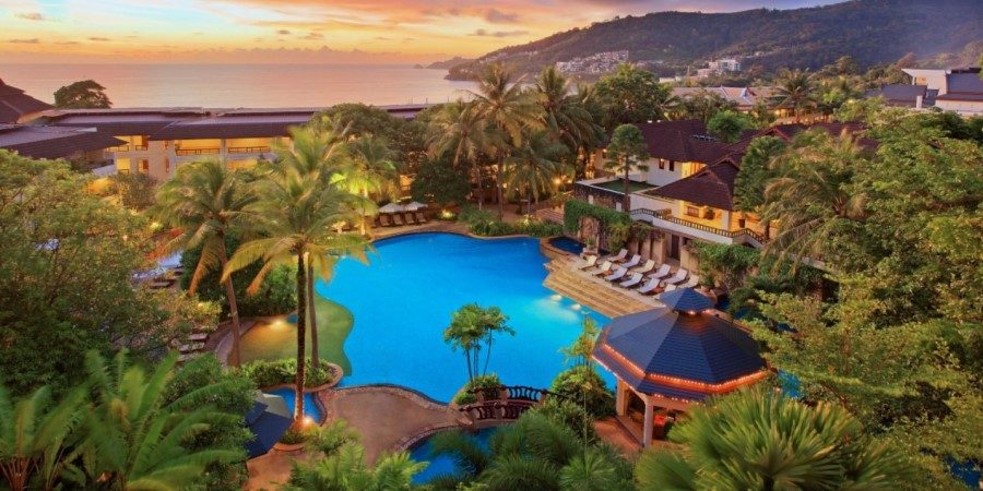 A resort nestled among vibrant greenery and tall trees, showcasing a serene and natural environment.
