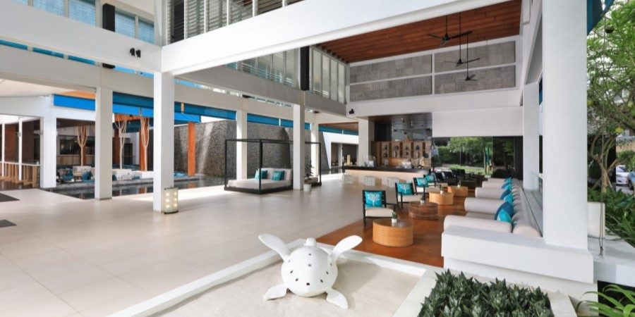 A modern hotel lobby featuring white furniture complemented by blue accents, creating a stylish and inviting atmosphere.