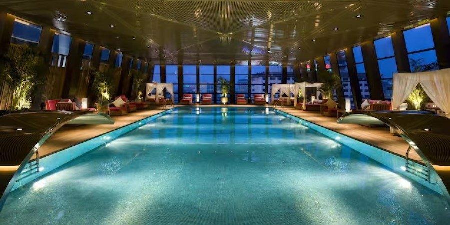 A spacious indoor swimming pool at the hotel, featuring clear water and surrounding lounge areas.