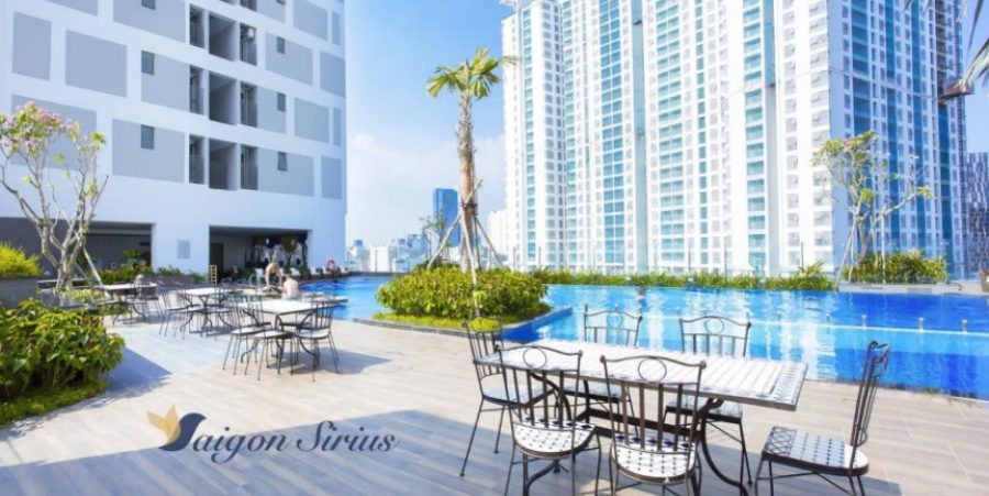 A tranquil pool area surrounded by tropical plants and equipped with comfortable lounge chairs.