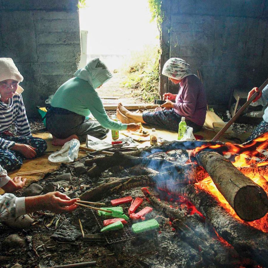 Women cooking around a fire. Credit: The Asahi Shimbun/Getty Images