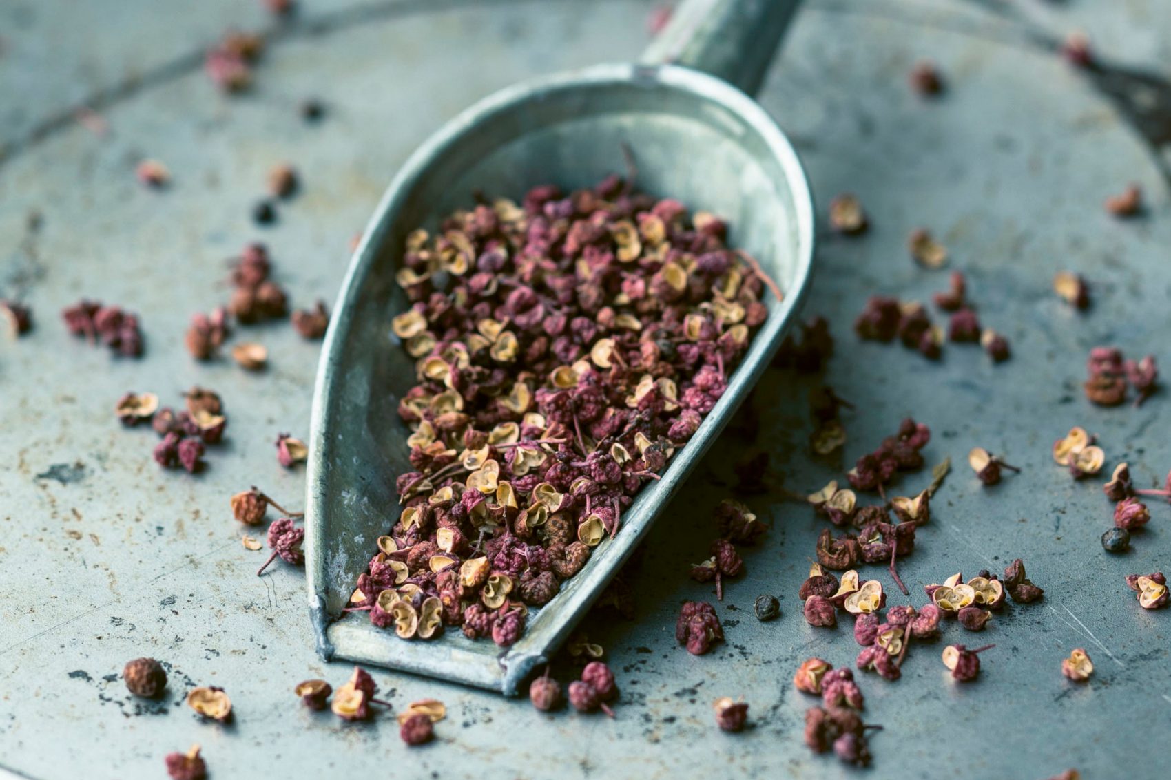 A scoop full of dried flowers sitting on top of a table