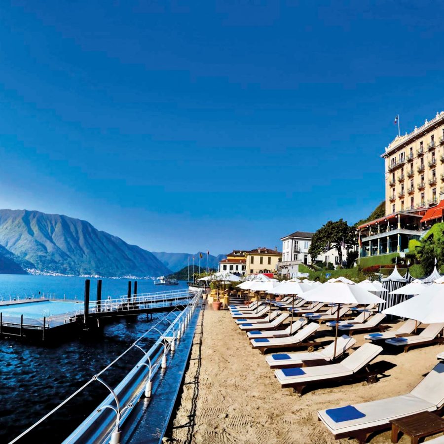 Swimming pool in the ocean with a row of deck chairs on the beach