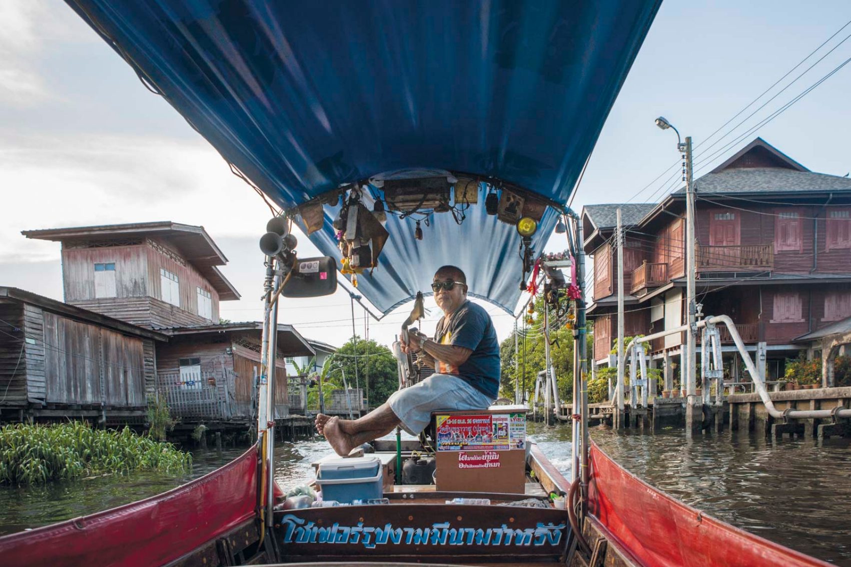 A man drives a longtail boat on the Chao Praya river in Bangkok. Credit: Cedric Arnold