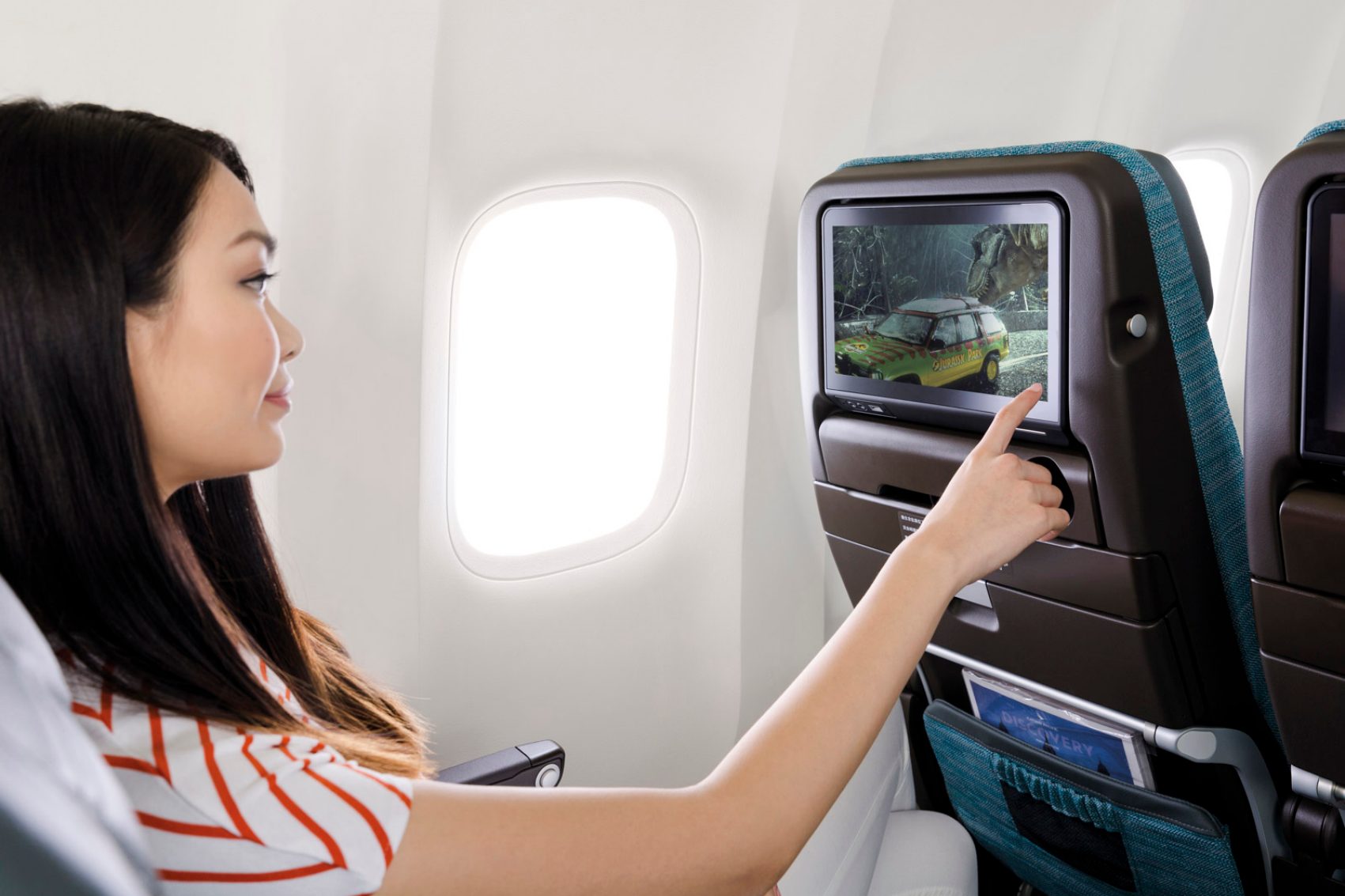 Lady looking at a seatback screen onboard a Cathay Pacific flight