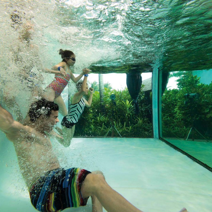 Underwater shot of family jumping into pool