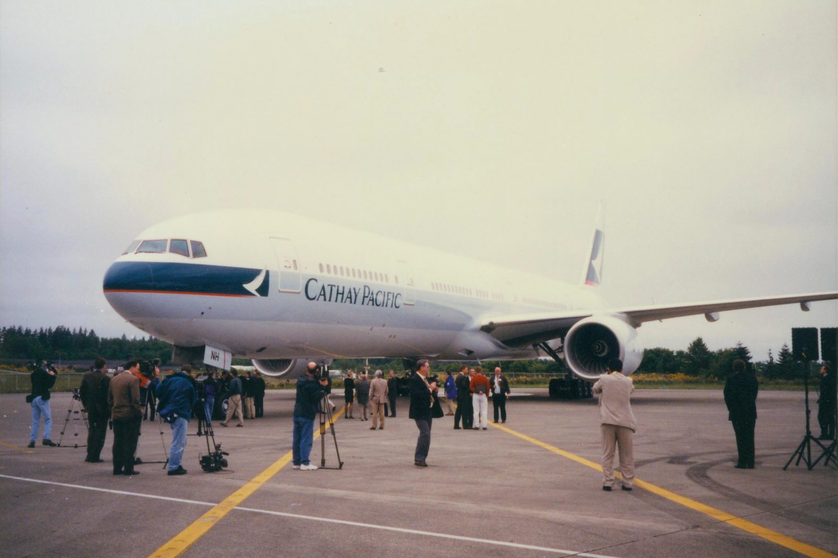 Press standing next to a Cathay Pacific Boeing 777-300 aircraft