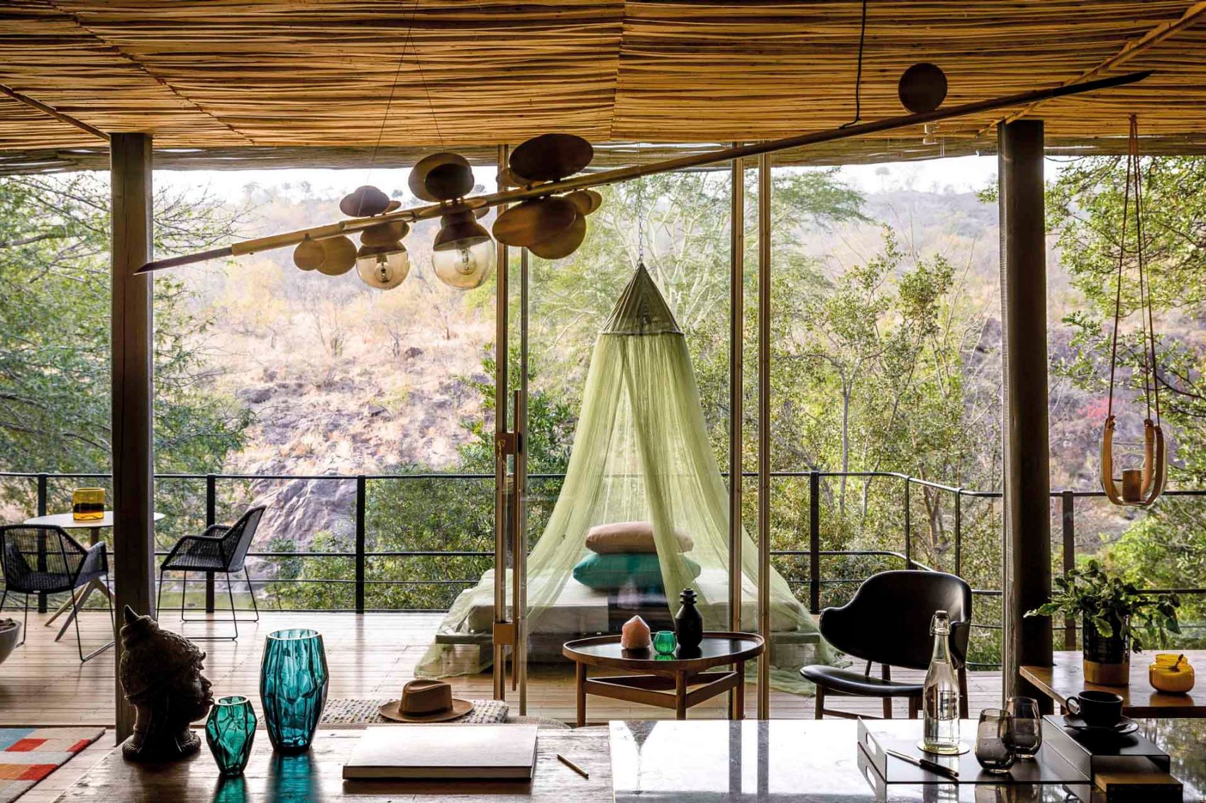Bed in balcony surrounded by greenery