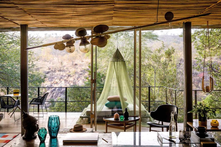 Bed in balcony surrounded by greenery