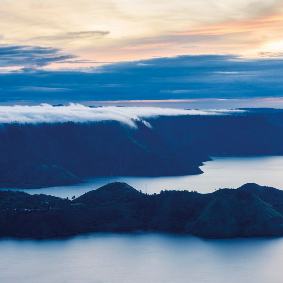 Sunset over a cliff with clouds and a lake
