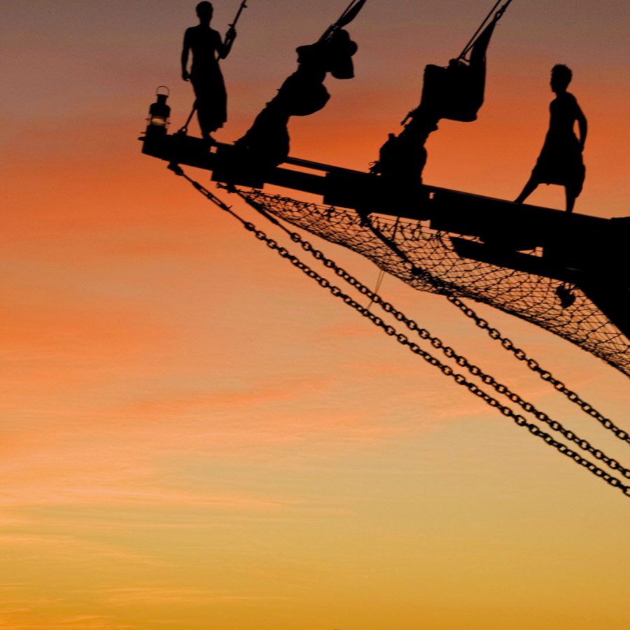 Silhouettes of two men on Silolona under sunset, Komodo National Park, Indonesia