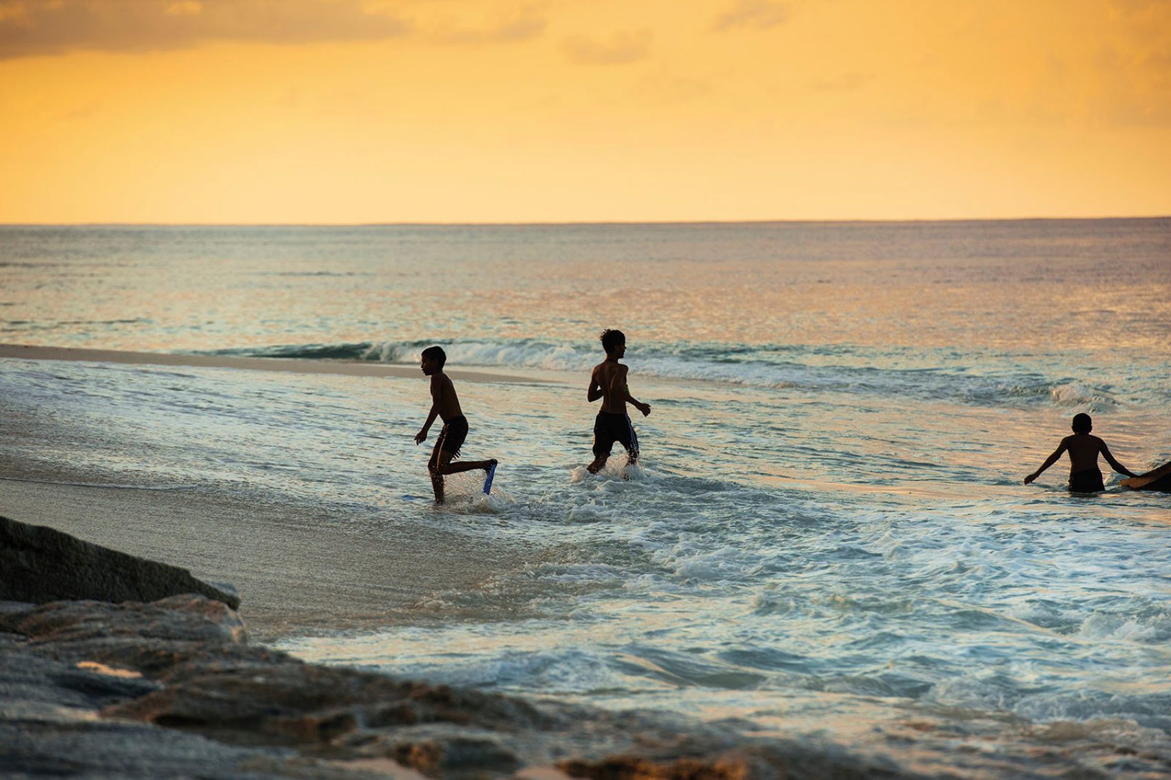 Children playing on the beach at sunset 