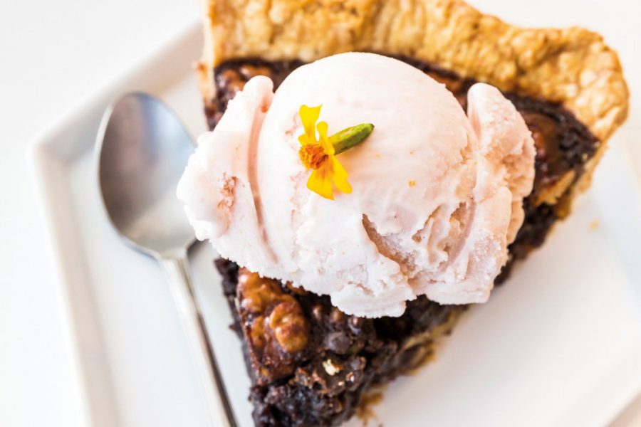 A slice of pie with a scoop of ice cream on top