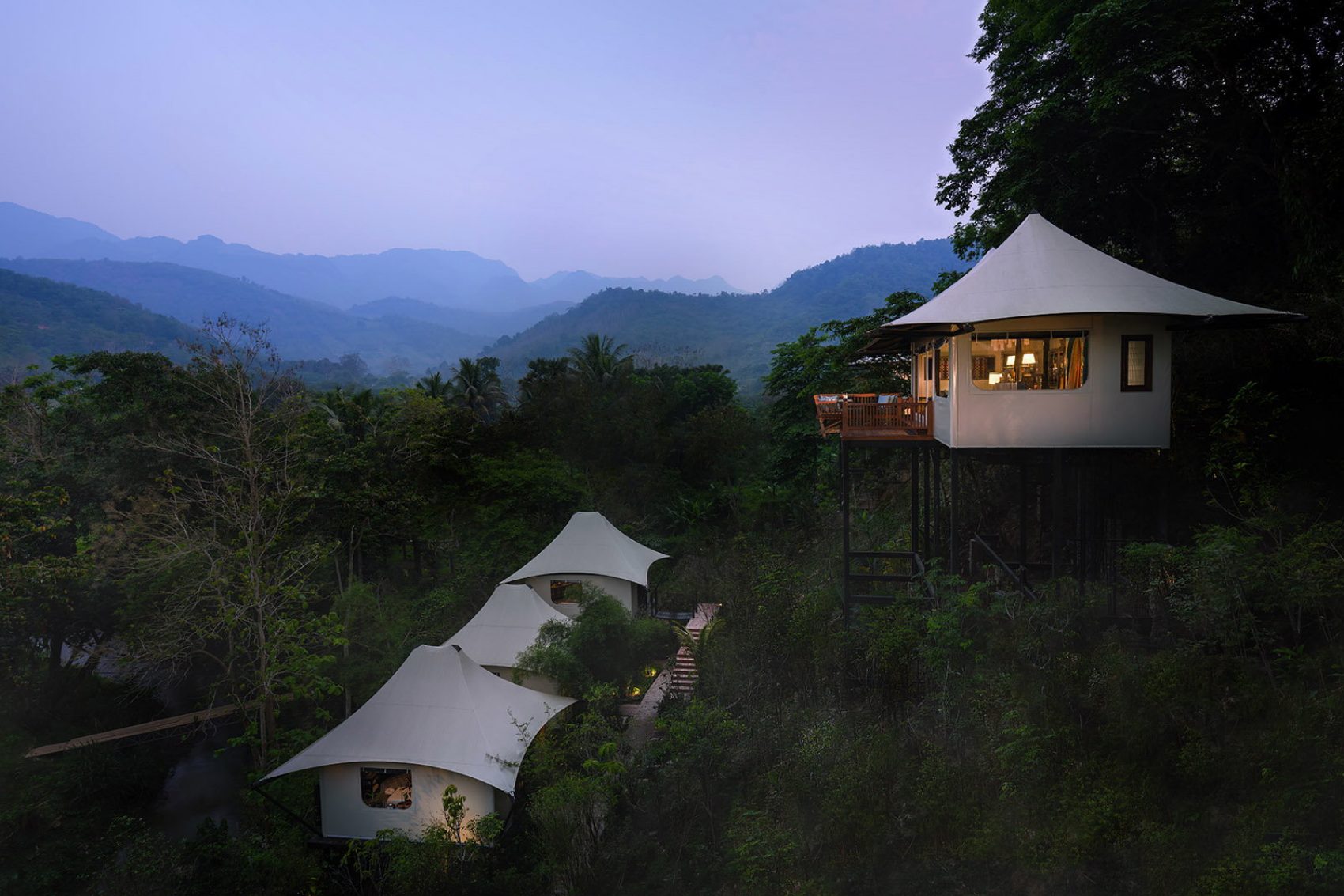 A group of luxury tents on the hillside of Rosewood Luang Prabang in Laos in the evening