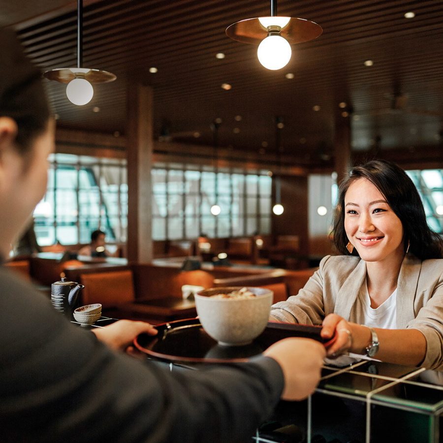 Woman being handed food in lounge