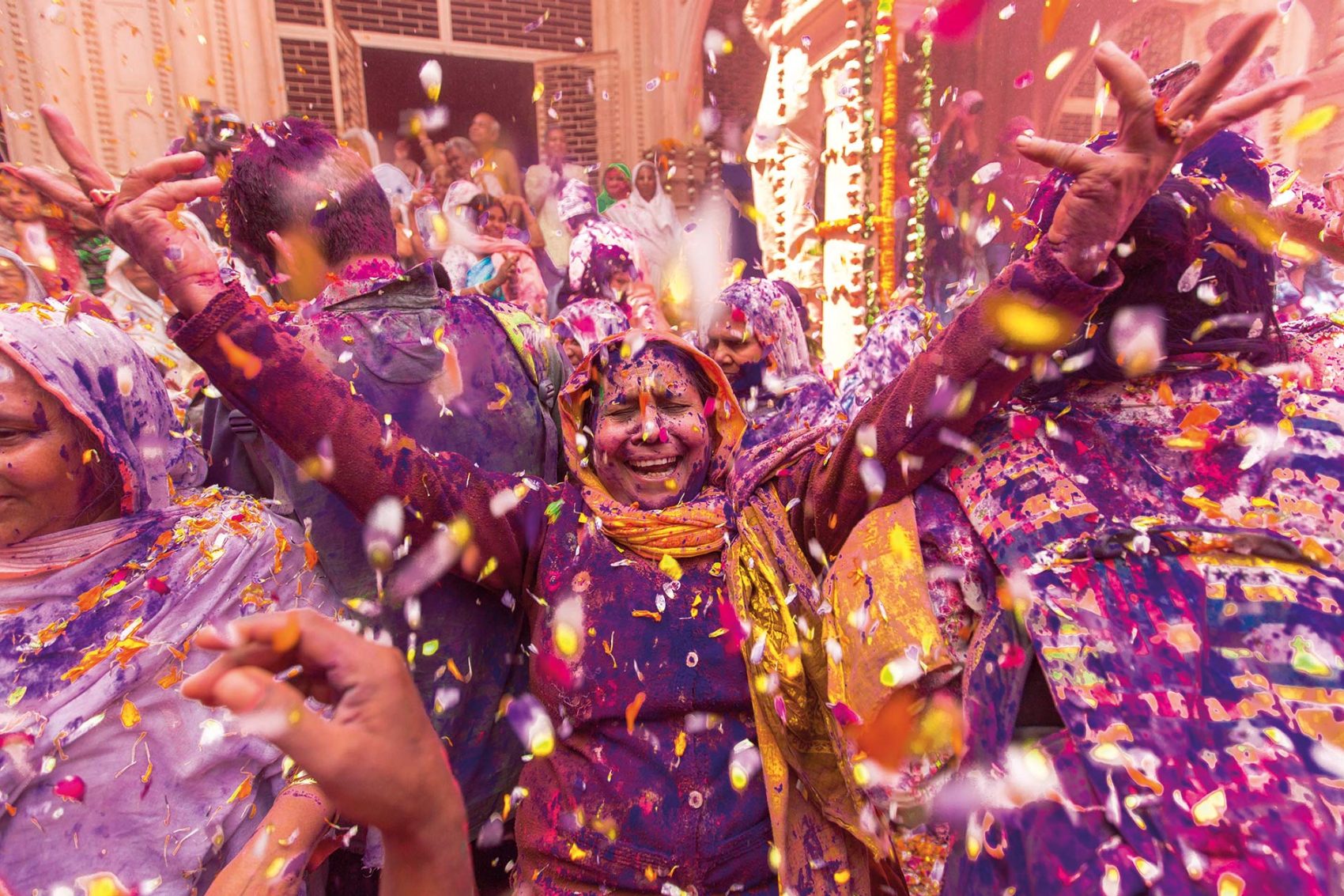 Woman smiling while covered in colour at a holi festival
