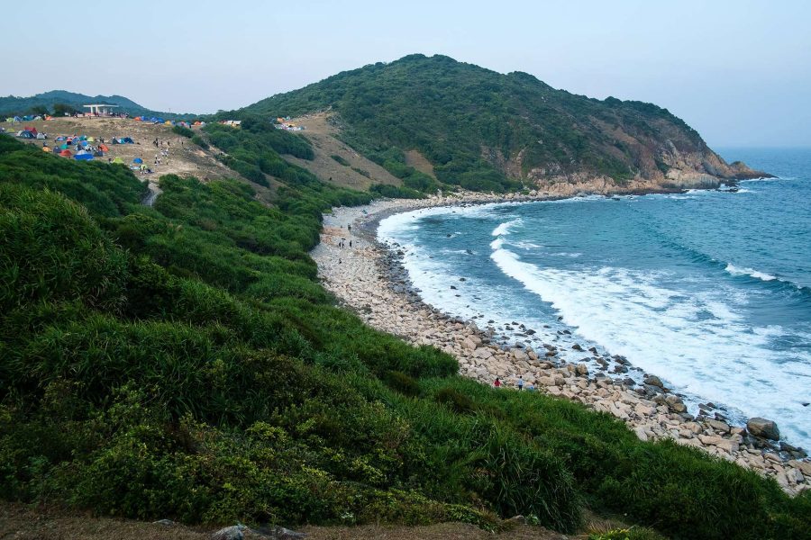 View of the ocean crashing against a rock beach in Hong Kong