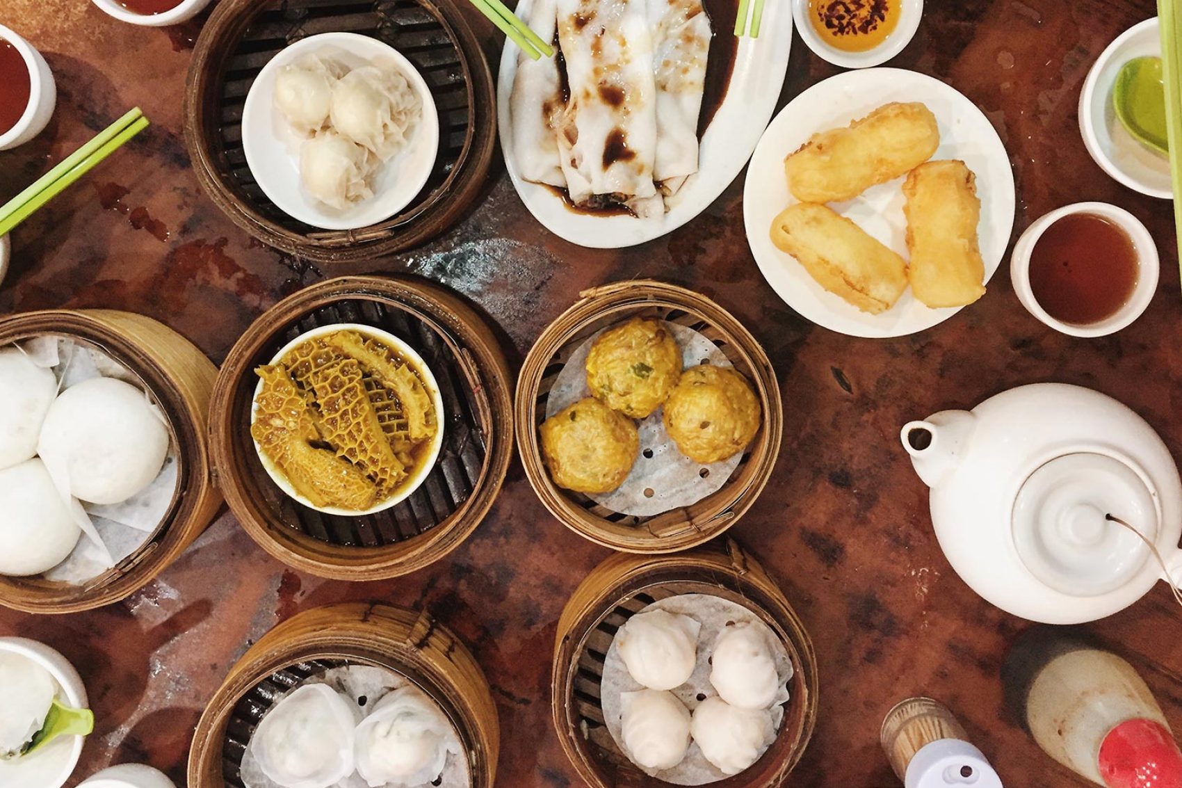 An aerial view of assorted dim sum dishes on plates and in steamers 