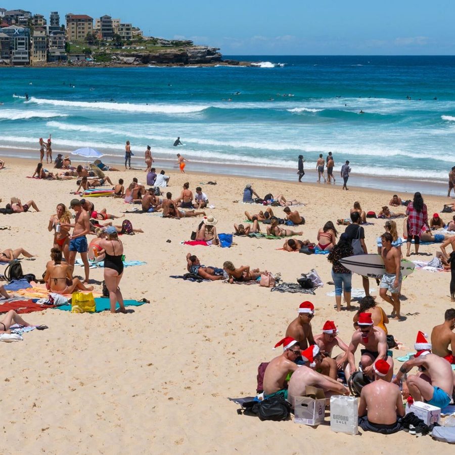 Group of young men wearing Santa hats on Christmas eve on Bondi beach Sydney 