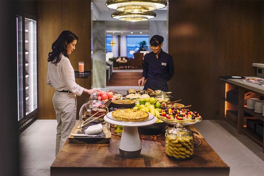 Woman choosing food from the kitchen area of the lounge