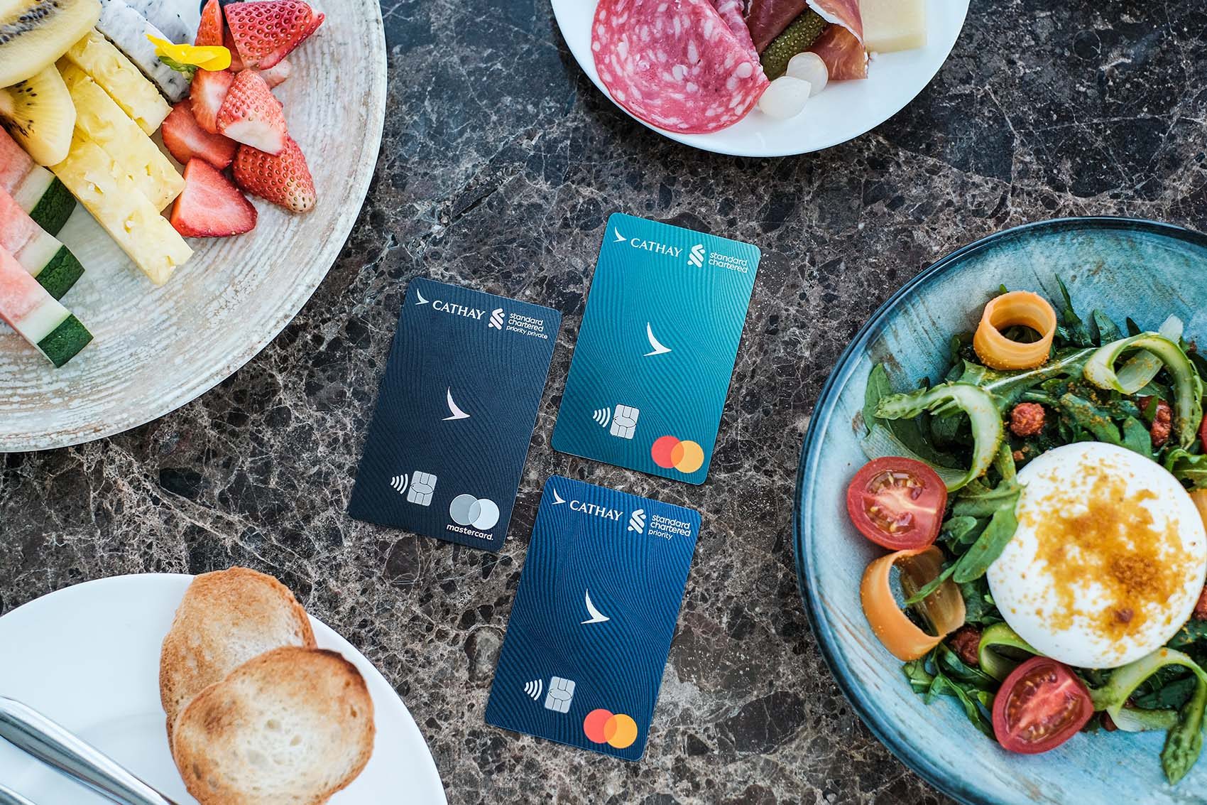 Cathay Pacific Standard Chartered credit cards surrounded by food