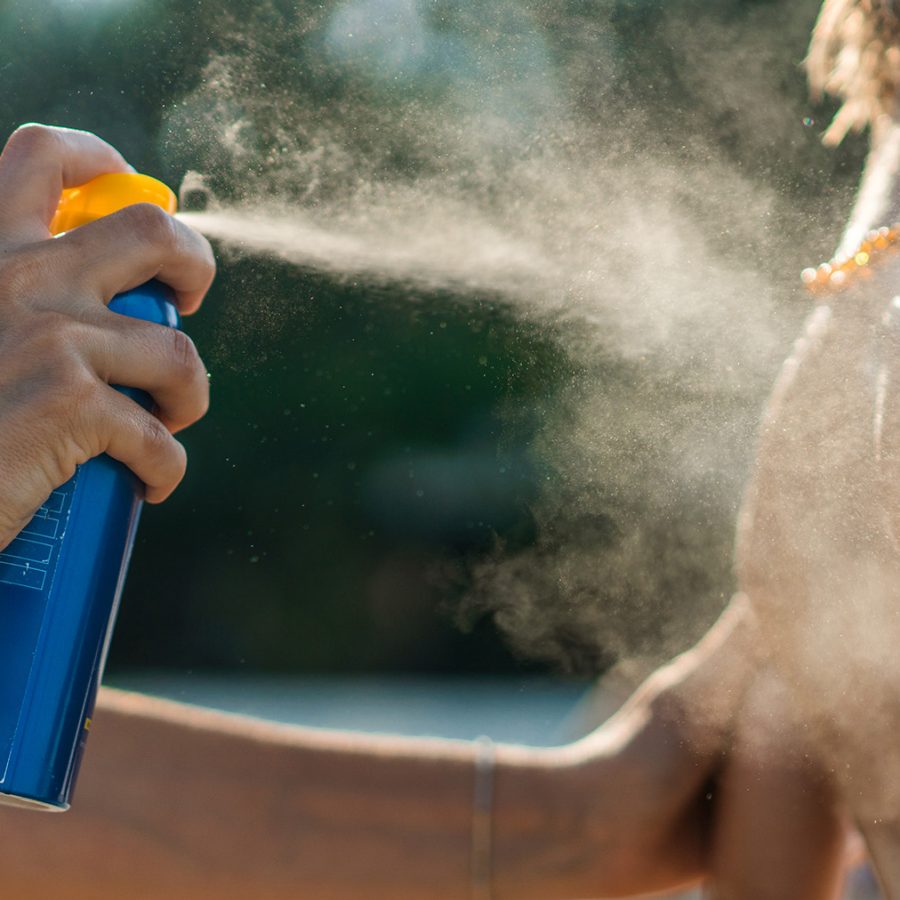 Sunscreen being sprayed on person