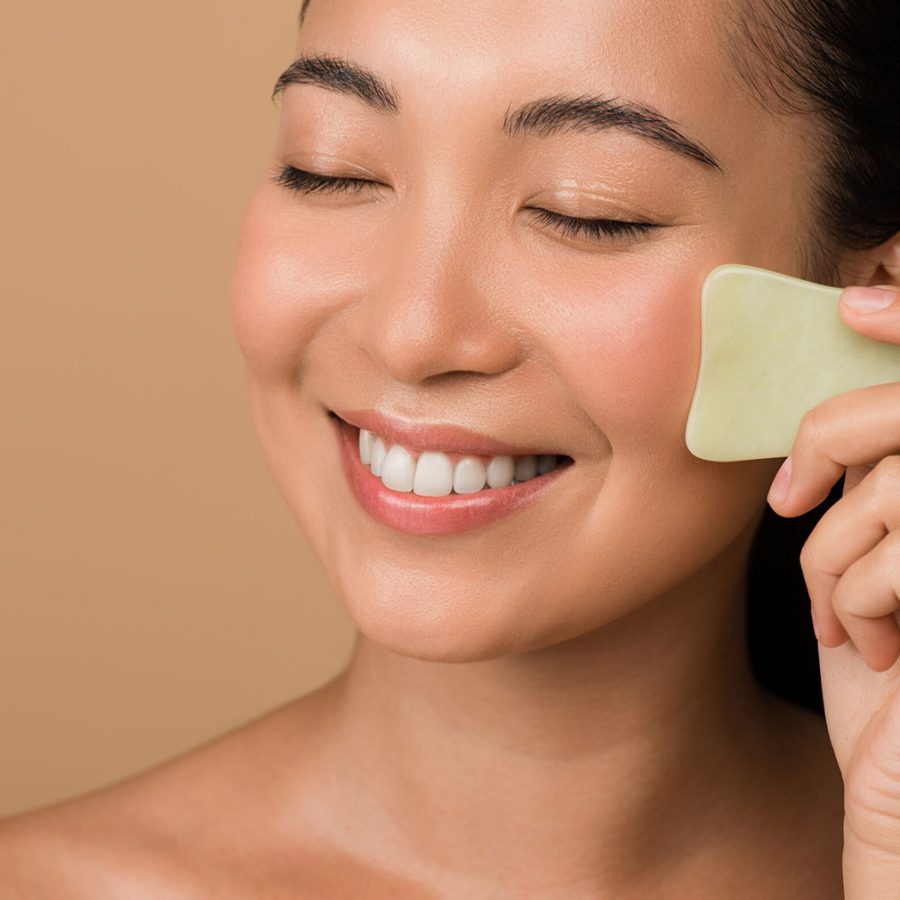 Woman smiling applying lotion to face