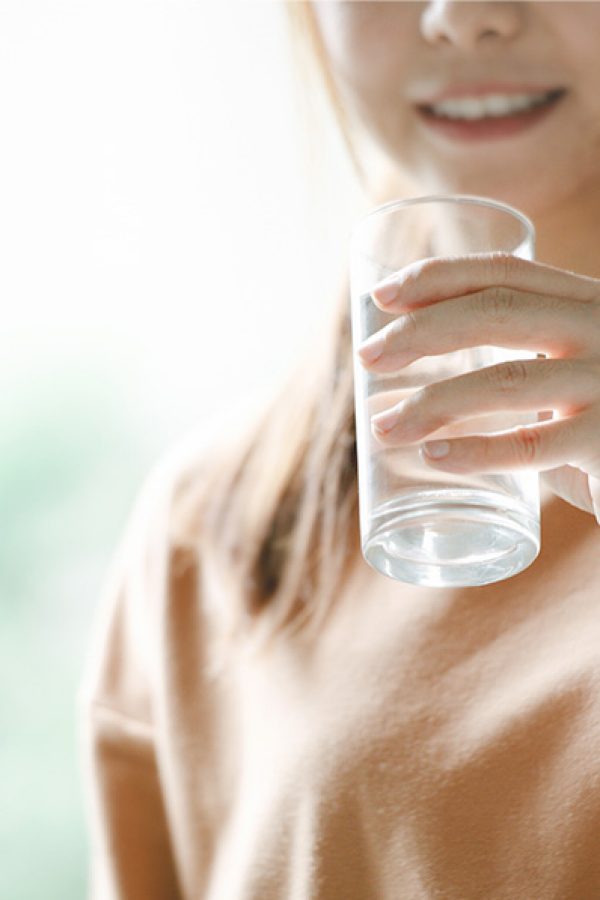 Woman holding glass of water. Credit: Getty images