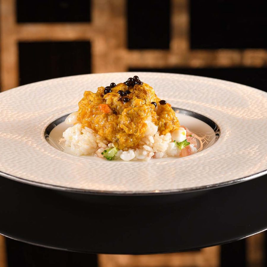 Sstir-fried lobster, hairy crab roe and egg white dish topped with crispy rice crackers