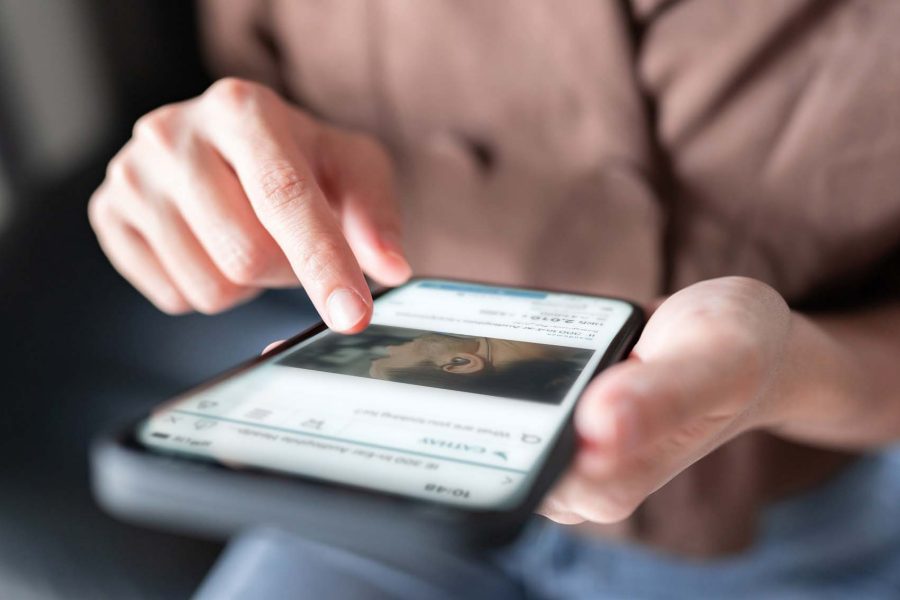 Person browsing the Cathay app on their phone. Credit: Getty Images