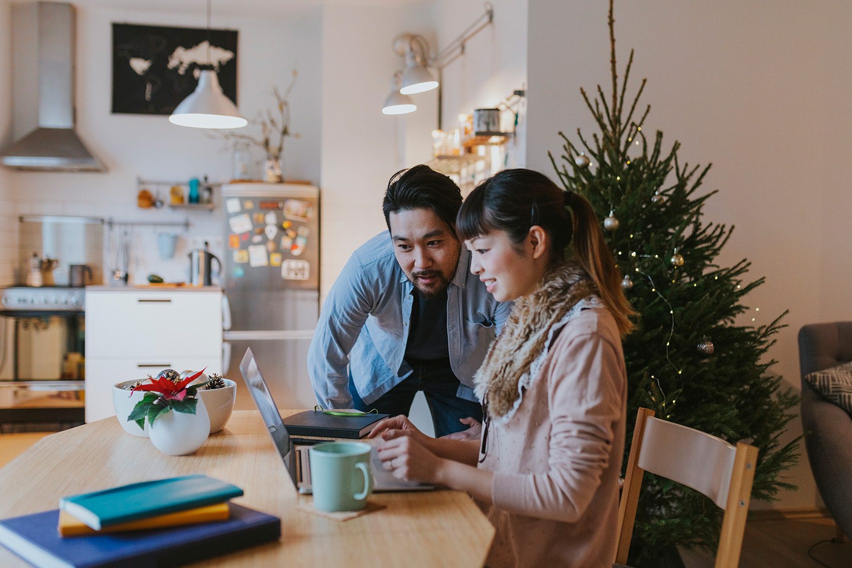 Two people shopping for Christmas gifts at a laptop. Credit: Getty Images