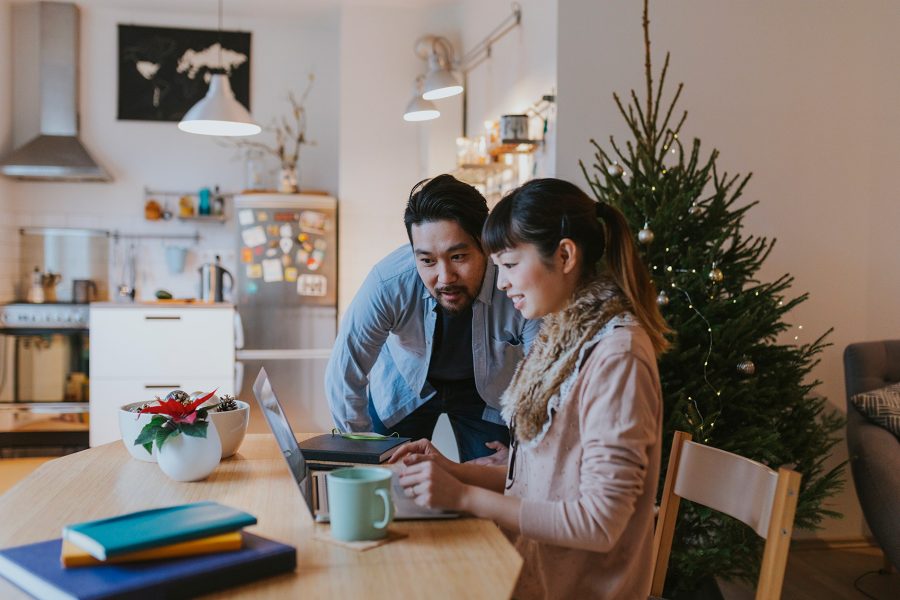 Two people shopping for Christmas gifts at a laptop. Credit: Getty Images