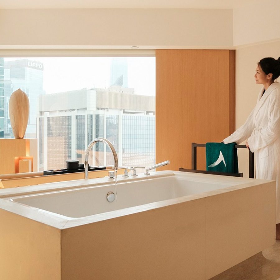 Woman looking out the window in The Upper House bathroom