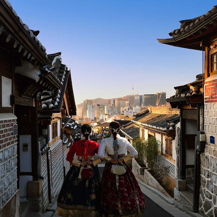 Two Hanbok-wearing women walking down the street in Bukchon Hanok Village