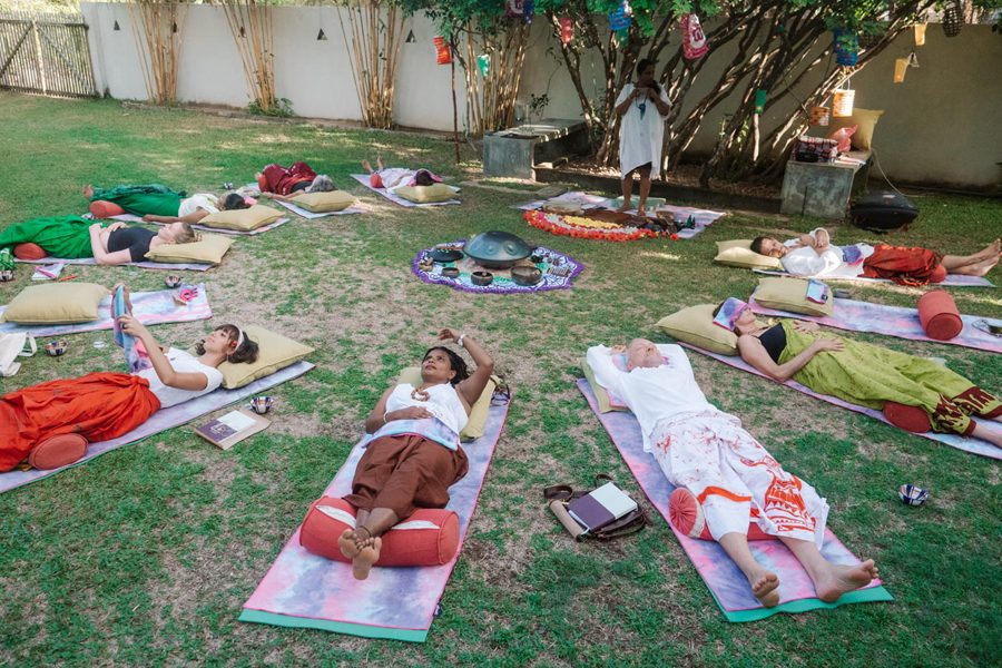 People meditating on yoga mats outside