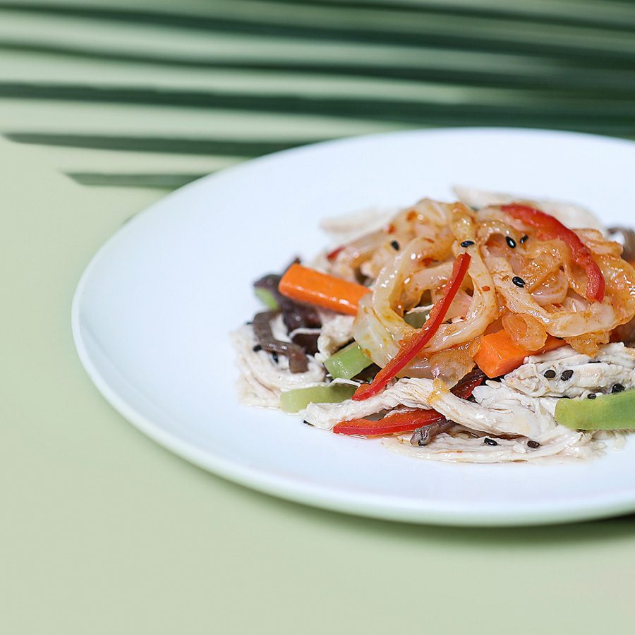 Shredded chicken and jellyfish salad with sesame dressing. Hand-shredded chicken is tossed with jellyfish in a sesame dressing, with a hint of chili and a sprinkling of pine nuts